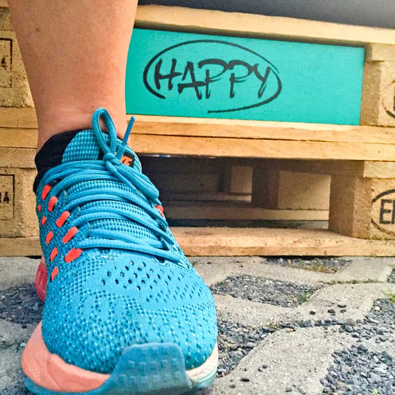 Laufschuh vor einer Kiste mit Europaletten