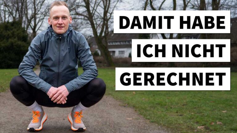 Ein motivierter Läufer in sportlicher Kleidung, bereit für den Marathonlauf, lächelt auf einem grünen Weg.