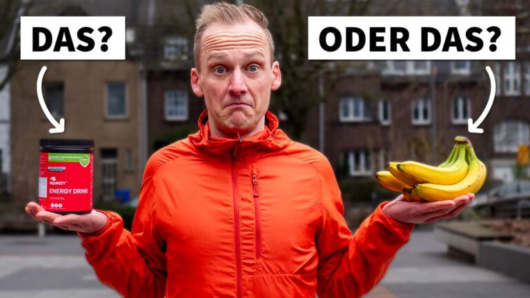 Ein Läufer in orangefarbener Jacke steht mit einem Energydrink und Bananen in den Händen. Ernährung beim Joggen im Fokus.
