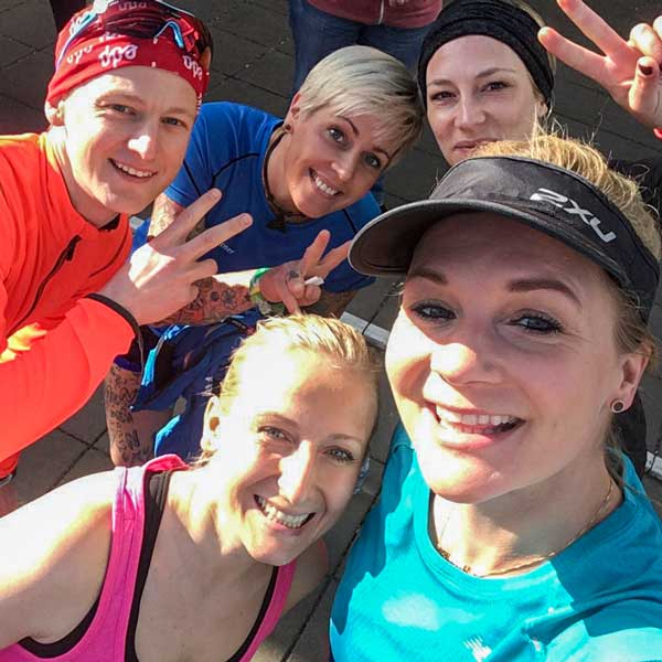 Eine fröhliche Gruppe von Läufern posiert für ein Selfie, bereit für das nächste Laufabenteuer. Fünftausend Schritte voller Freude!