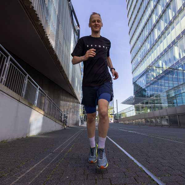Ein fröhlicher Läufer joggt energisch durch eine moderne Stadtlandschaft, bereit für neue Herausforderungen und Fünftausend Schritte.