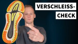 Ein Läufer zeigt auf die abgenutzte Sohle eines Laufschuhs. Wann brauchst du neue Laufschuhe? 3 Anzeichen für den Verschleiß werden hier erklärt.